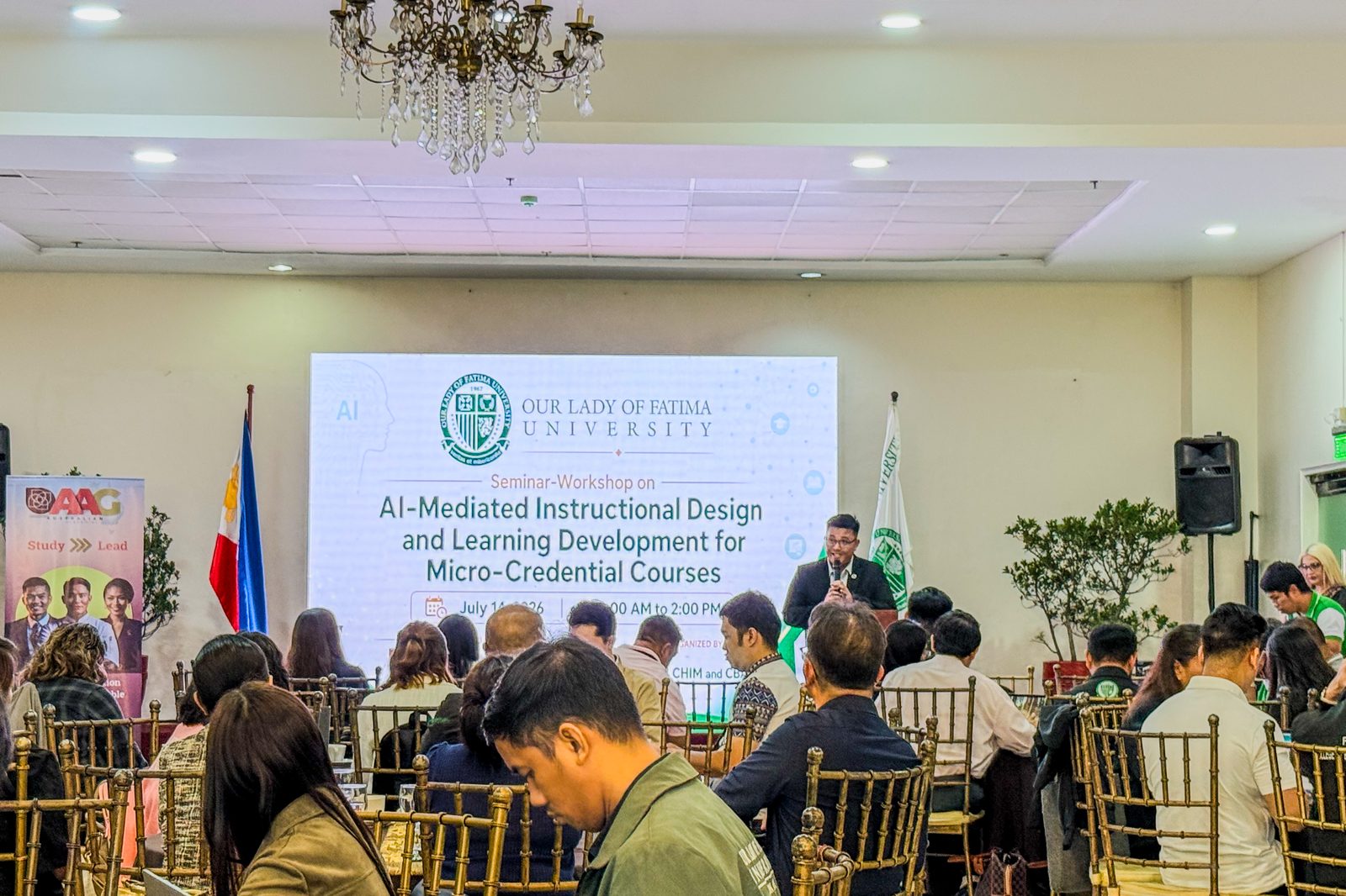 A full function room of educators seated at round tables, facing a screen that reads Seminar-Workshop on AI-Mediated Instructional Design and Learning Development for Micro-Credential Courses, with the Our Lady of Fatima University seal
